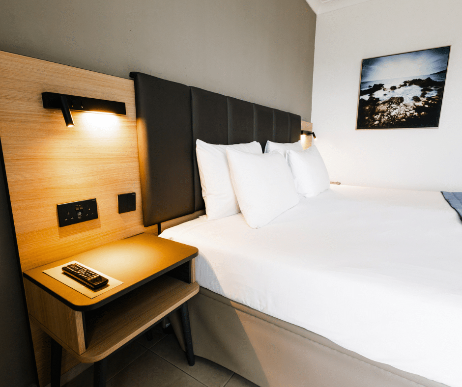 Hotel room furniture at Qawra Palace Resort & Spa in Malta featuring upholstered headboard and bedside unit